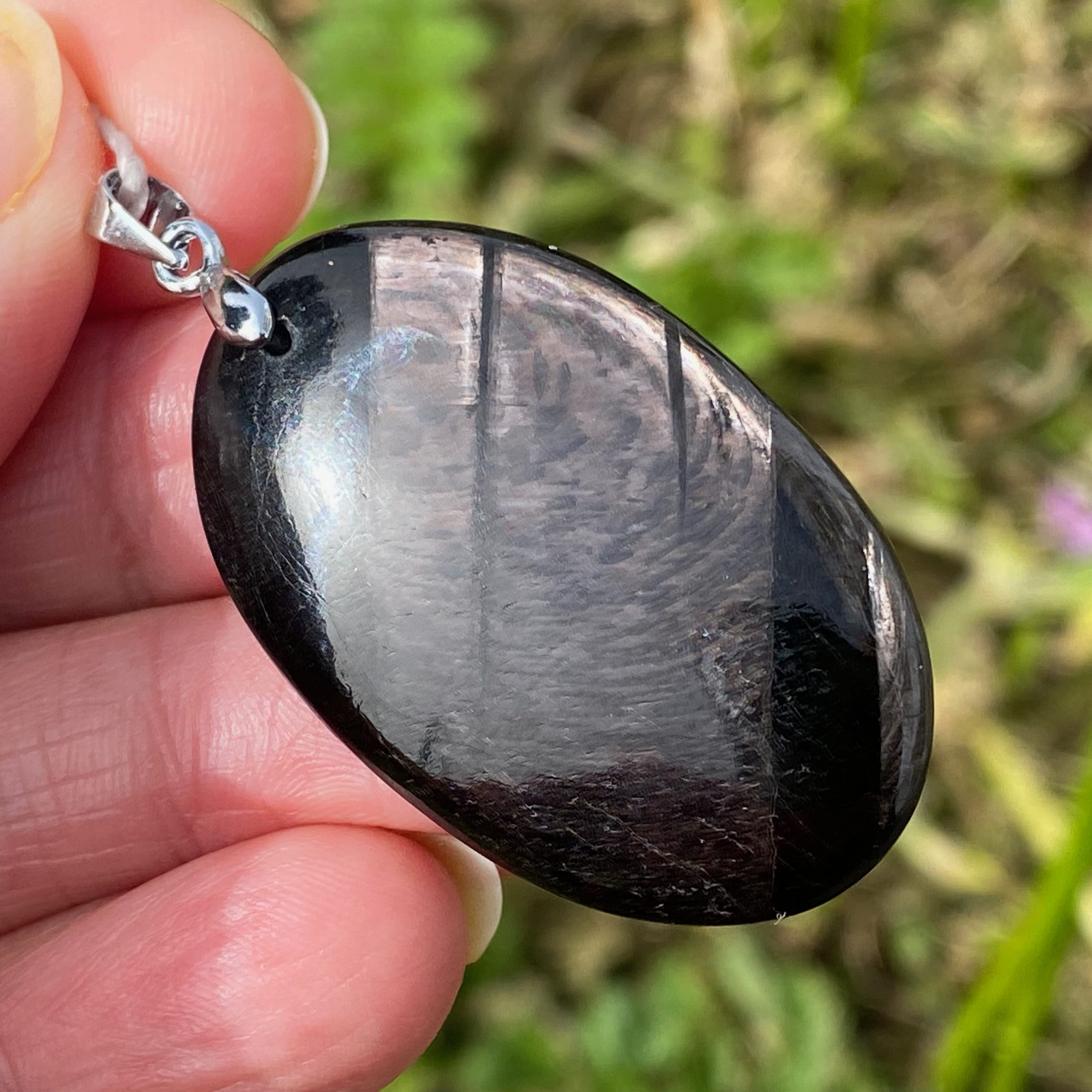 Pendentif en pierre naturelle d'hypersthène noire aux reflets métalliques monté sur bélière.