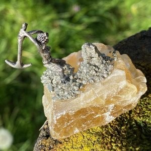 Sculpture miniature artisanale d'un mineur en métal avec une pioche sur un bloc brut de Fluorite jaune naturelle, parsemé de cristaux de Pyrite dorée étincelante.