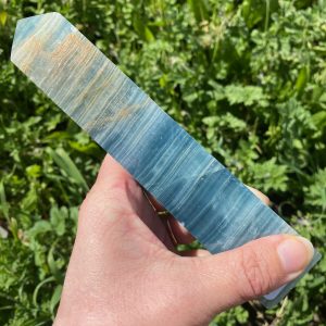 Grande tour polie en onyx bleu naturel avec rayures légères, forme obélisque.