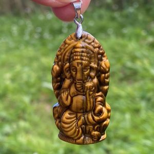 Pendentif en oeil de tigre naturelle en forme de ganesh ce protecteur de foyer et bien plus encore.