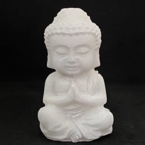 Statuette Bouddha sculpté en jade blanc, mains jointes en position de prière, fond noir