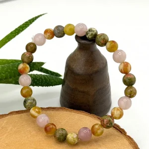 Bracelet lâcher-prise en perles de pierres naturelles aux nuances vertes et roses, présenté dans une ambiance zen.