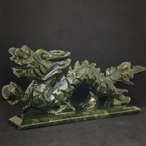 Sculpture dragon impérial chinois taillée en jade vert, posée sur un socle assorti