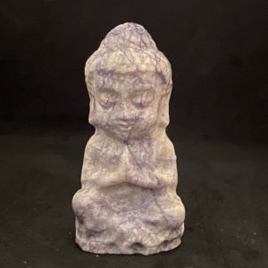 Petit bouddha sculpté en lépidolite violette, en position de prière ou de méditation.