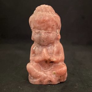 Petit bouddha en pierre rhodonite rose saumon, figurine sculptée en position de méditation, vue de face.