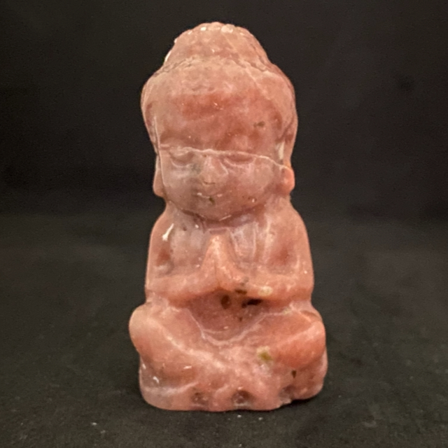 Petit bouddha en pierre rhodonite rose saumon, figurine sculptée en position de méditation, vue de face.